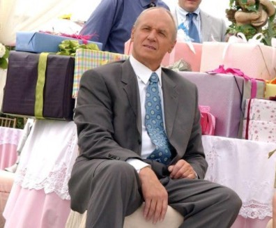 A man sits surrounded by presents in this image from Warner Bros. Studios