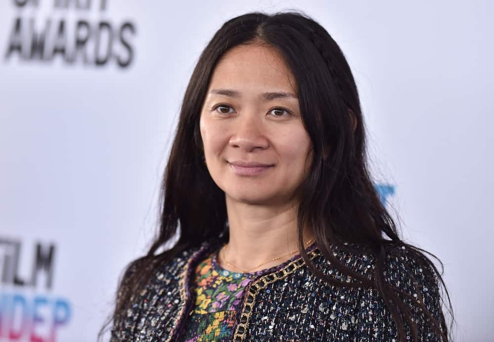 Chloé Zhao smiling at a press event in this image from Shutterstock