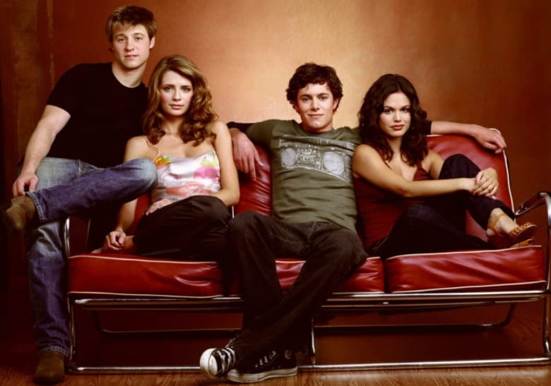Four people sit on a couch in this image from Warner Bros. Studios.