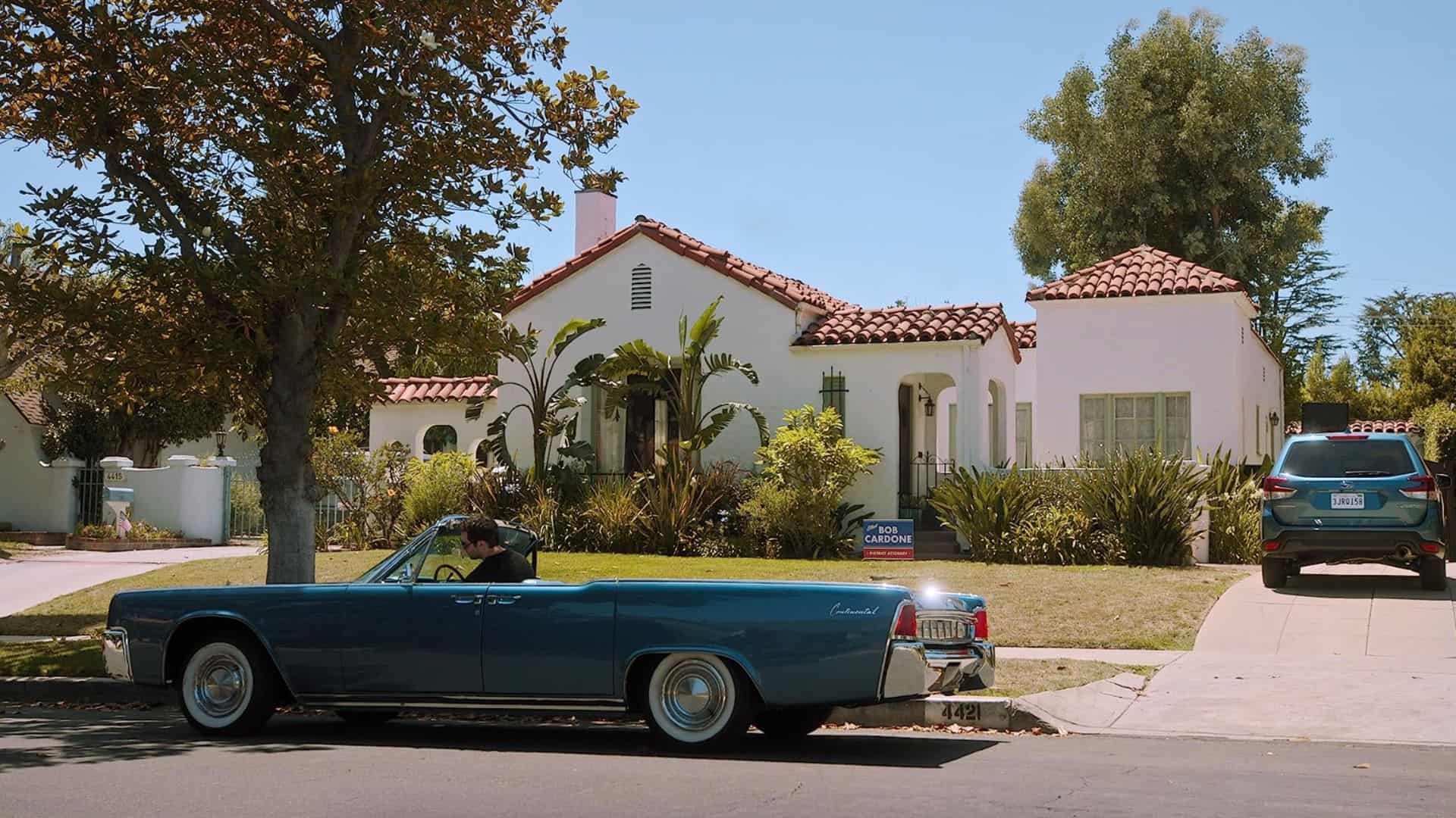 Manuel Garcia-Rulfo sits in a blue Lincoln Town Car in front of a house in this image from A+E Studios.