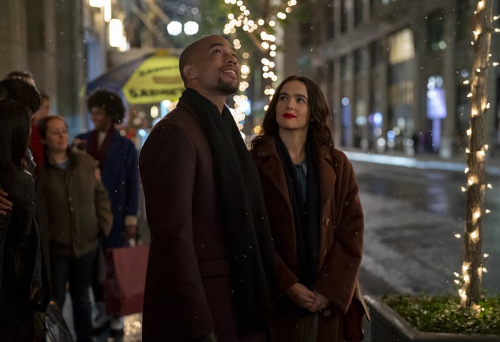 Ethan and Rachel walking along a holiday-lit New York street