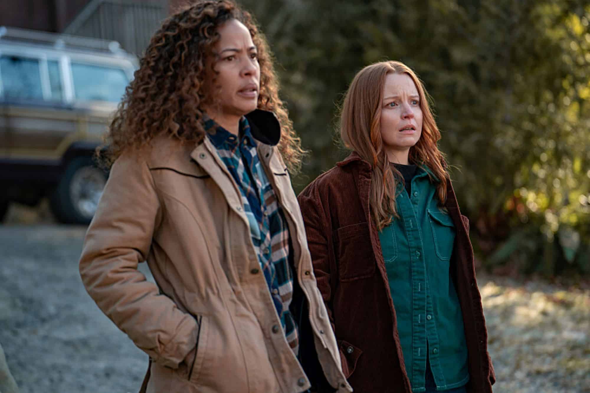 Two women stand next to each other staring at something in this photo by Showtime