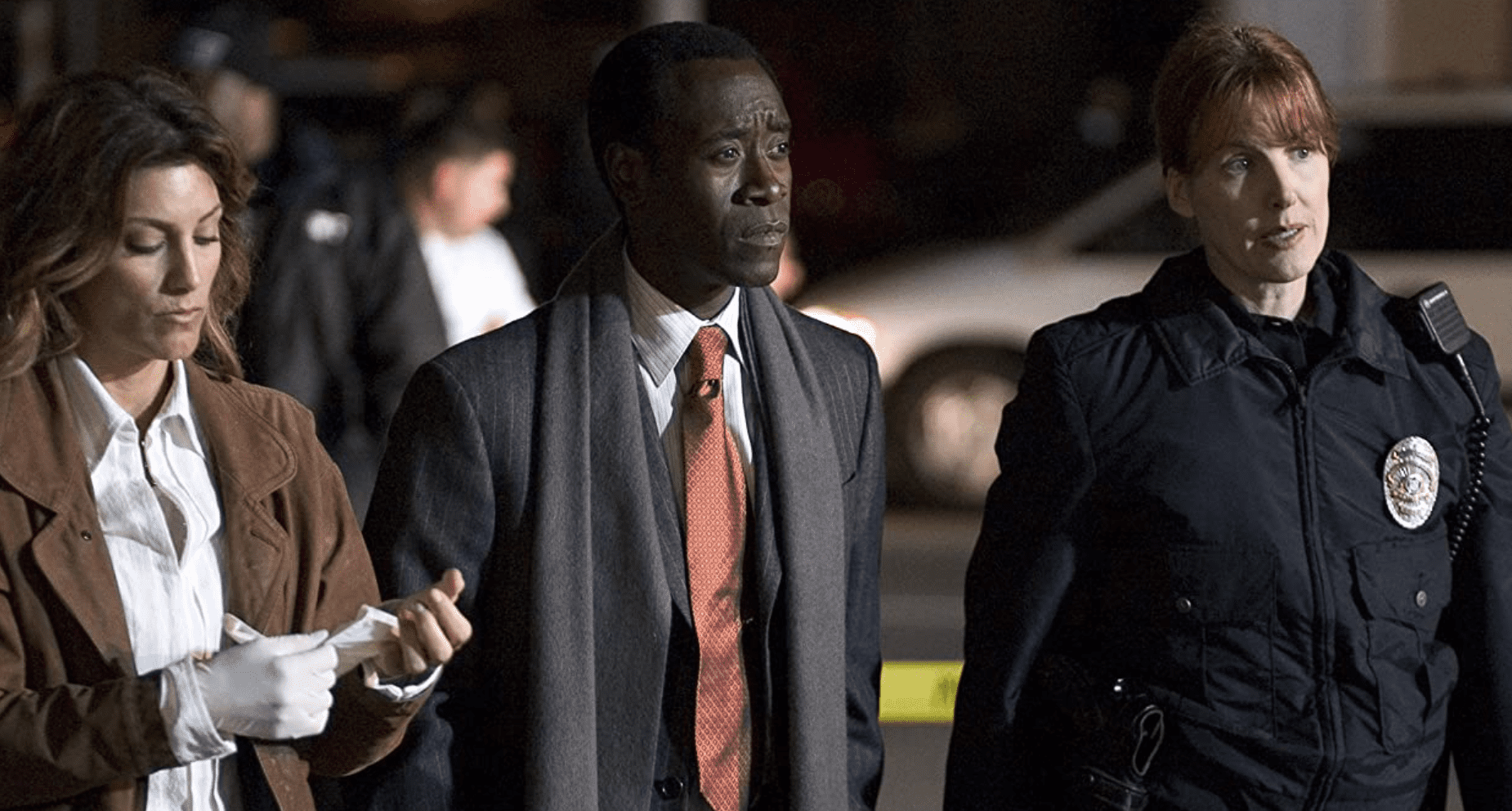 A police officer stands next to two detectives at a crime scene