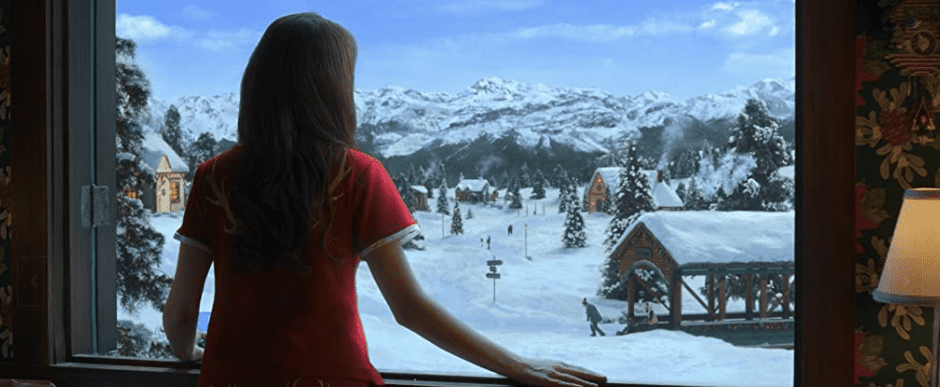 Noelle looks out her window at a snowy village.
