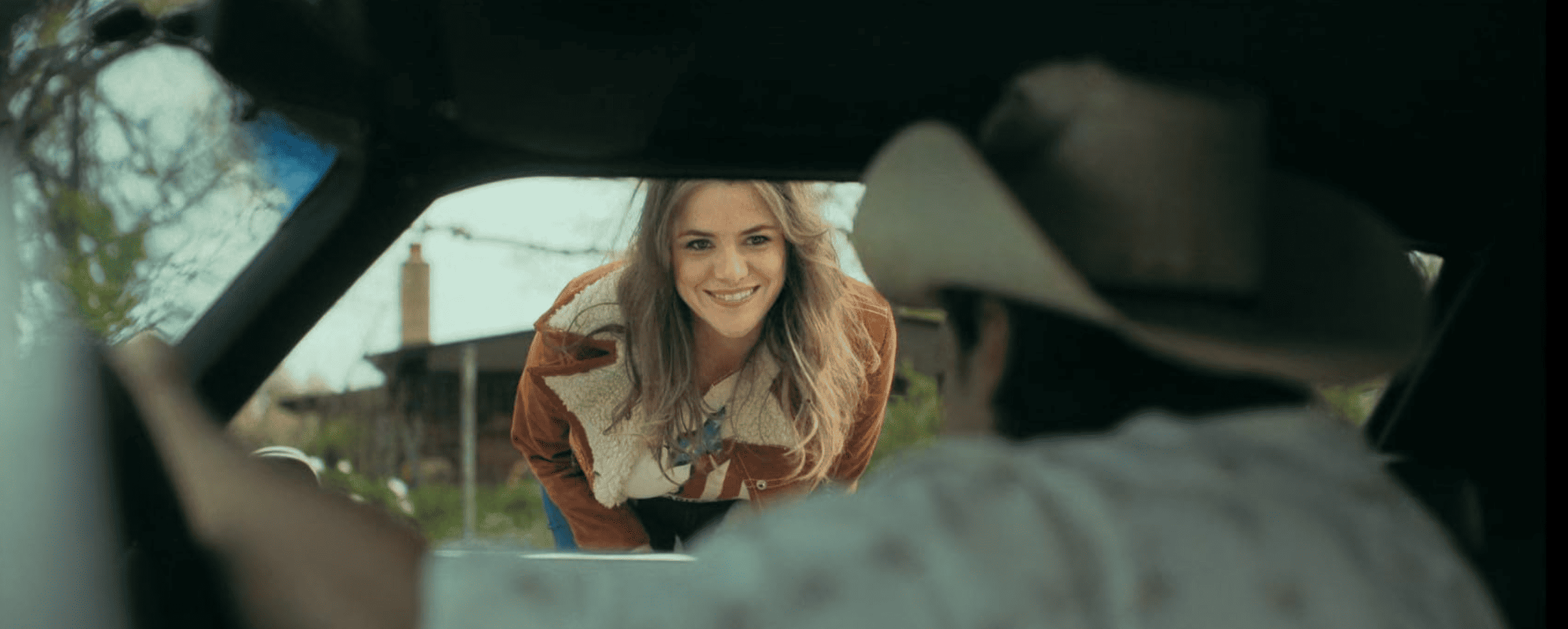 A woman talks to a man from outside a car window in this image from FXP