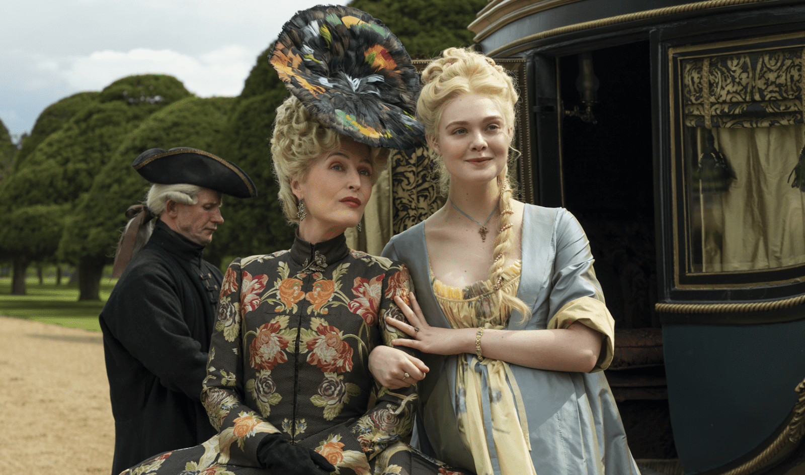 Two women wearing period pieces next to a horse-drawn car