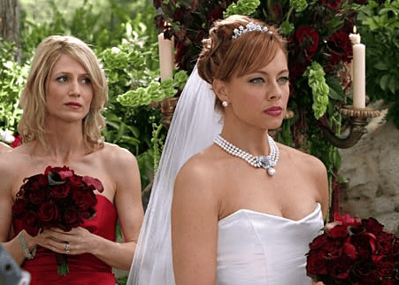 A woman holding flowers stands behind a bride in this image from Warner Bros. Studios.